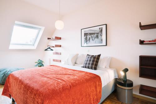 a bedroom with a bed with a red blanket at Smartflats - Central Ghent in Ghent