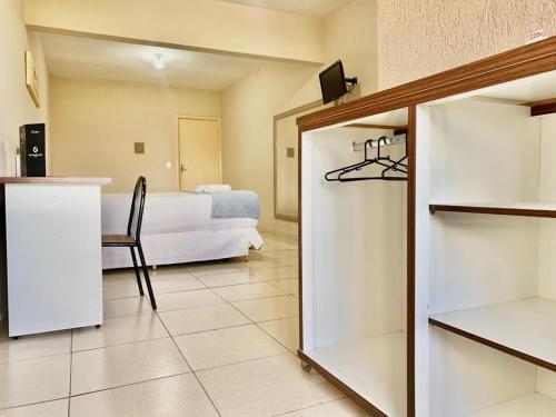 a bedroom with a bed and a table and a chair at Hotel Sublime - Pistão Sul - Próximo a Universidade Católica de Brasília in Taguatinga
