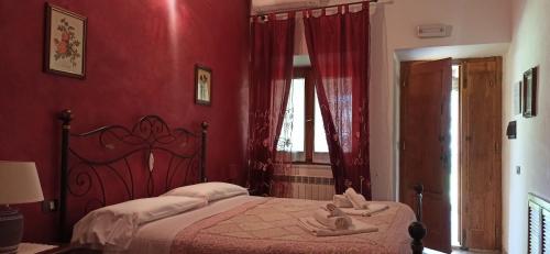 a red bedroom with a bed with two people on it at Agriturismo Le Chicche di Mafalda in Montemerano