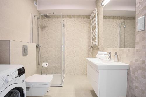 a bathroom with a shower and a toilet and a sink at NovumApartamenty in Kołobrzeg