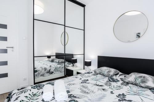 a bedroom with a bed and a mirror at NovumApartamenty in Kołobrzeg