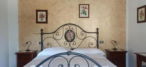 a bedroom with a bed with a wrought iron headboard at Agriturismo Le Chicche di Mafalda in Montemerano