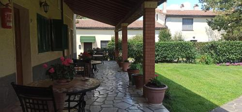 an outdoor patio with tables and chairs and a yard at Agriturismo Le Chicche di Mafalda in Montemerano