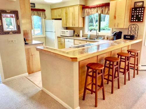 a kitchen with a island with bar stools in it at G4 Modern home with AC within walking distance of golf course and Mt Washington Hotel in Carroll