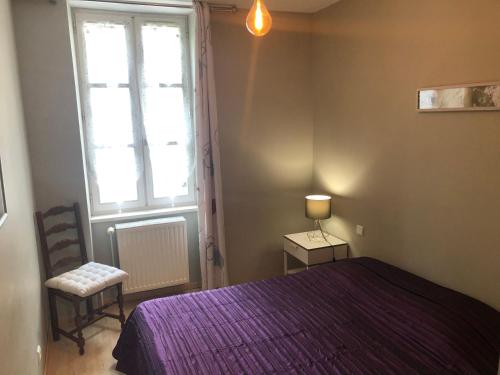 a bedroom with a purple bed and a window at L'embellie in Treffort