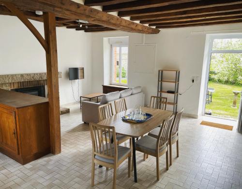 a living room with a wooden table and chairs at La Jaguelinière in Astillé