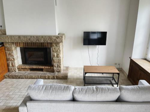 a living room with a couch and a fireplace at La Jaguelinière in Astillé