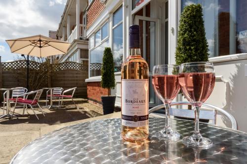 a bottle of wine sitting on a table with two glasses at Palm Court in Skegness
