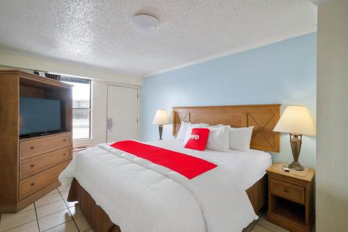 a bedroom with a large white bed and a flat screen tv at OYO Hotel Rockport- Bay View in Rockport