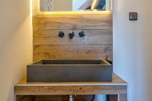 a stainless steel sink in a bathroom with wooden walls at Infinity Sky Zlatibor in Zlatibor