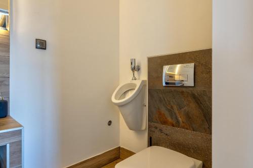 a bathroom with a toilet with a urinal on the wall at Infinity Sky Zlatibor in Zlatibor