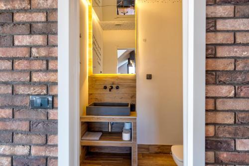 a bathroom with a sink and a brick wall at Infinity Sky Zlatibor in Zlatibor