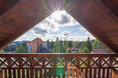 a view from a wooden balcony with a large window at Infinity Sky Zlatibor in Zlatibor