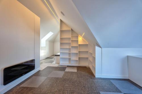 an attic hallway with white shelves and a fireplace at Infinity Sky Zlatibor in Zlatibor