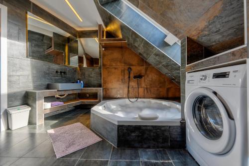a bathroom with a tub and a washing machine at Infinity Sky Zlatibor in Zlatibor