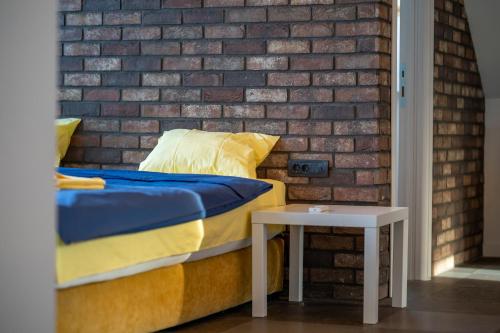 a bed with a side table next to a brick wall at Infinity Sky Zlatibor in Zlatibor