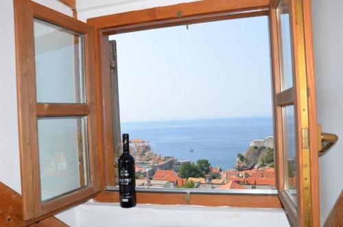 Apartments Brautović في دوبروفنيك: زجاجة من النبيذ موضوعة على حافة النافذة
