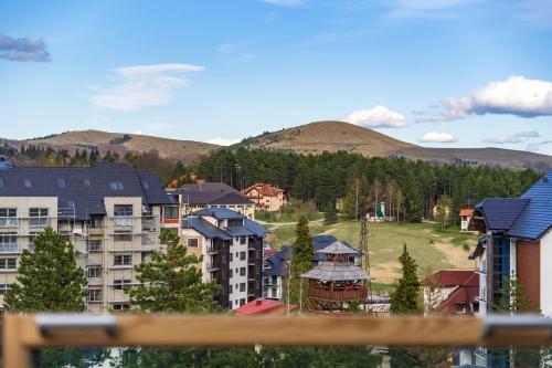 a group of buildings with mountains in the background at Infinity Sky Zlatibor in Zlatibor
