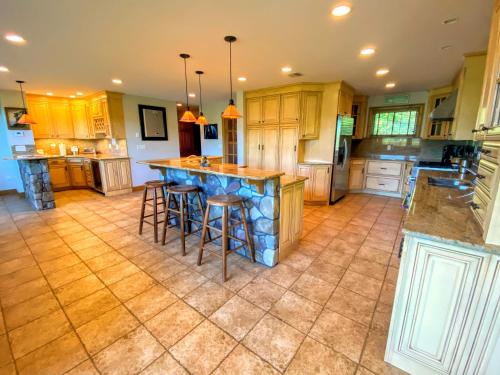 a large kitchen with a large island with bar stools at M1 Luxury home a short walk from the Mount Washington Hotel AC heated floor stunning views in Carroll