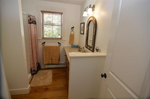 y baño con lavabo y espejo. en MO Private home in beautiful wooded setting - close to Bretton Woods AC, en Carroll