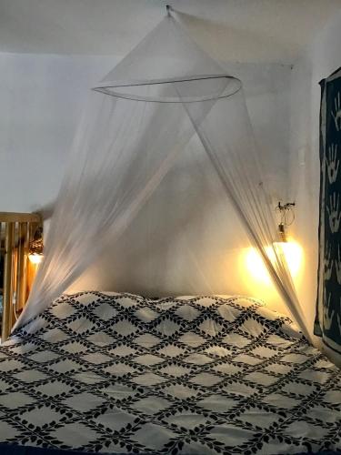 a bedroom with a bed with a mosquito net at Chez Cécile Home in Mochlos