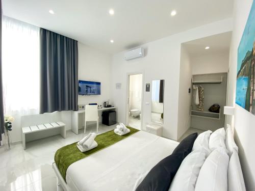 ein weißes Schlafzimmer mit einem großen Bett und einem Badezimmer in der Unterkunft Villa Gabriella - Rooms & Breakfast in Sant'Agnello