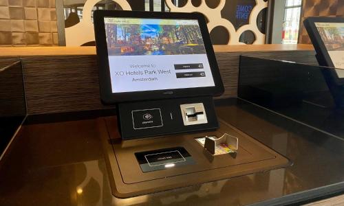 um tablet em cima de uma mesa de vidro em XO Hotels Park West em Amesterdão