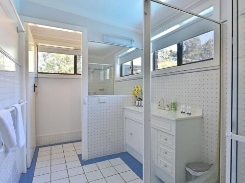 a white bathroom with a sink and a mirror at Blaxlands Homestead - Nothing is closer opposite Hope Estate with Wifi and Pool plus Fireplace in Pokolbin