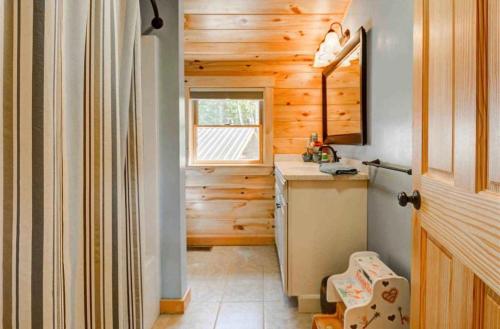 eine kleine Küche mit Holzwänden und einem Fenster in der Unterkunft OE Beautiful modern log home on 17 acres private views fire pit Ping Pong AC in Whitefield