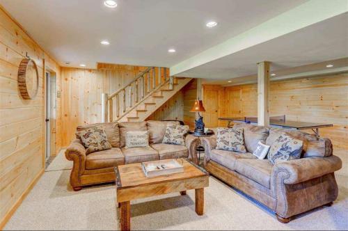a living room with two couches and a table at OE Beautiful modern log home on 17 acres private views fire pit Ping Pong AC in Whitefield