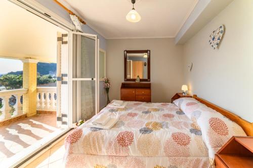 a bedroom with a bed and a balcony at Serenity in Pelekas