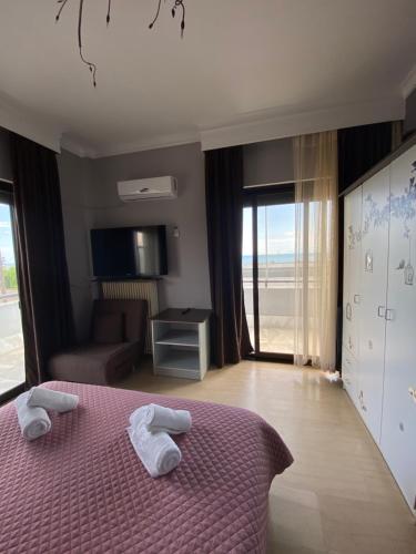 a bedroom with a purple bed with towels on it at Alexander Apartments in Alexandroupoli