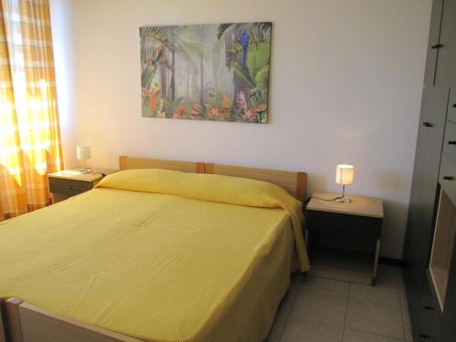a bedroom with a bed with a yellow bedspread at Appartamento A Mare in Grado