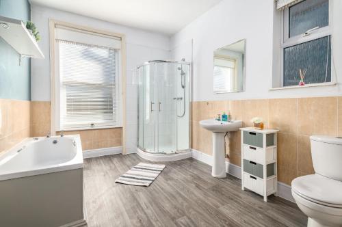 La salle de bains est pourvue d'une douche, de toilettes et d'un lavabo. dans l'établissement Large Contractor House in Great Location with FREE Parking - Staycation welcome, à Bedford