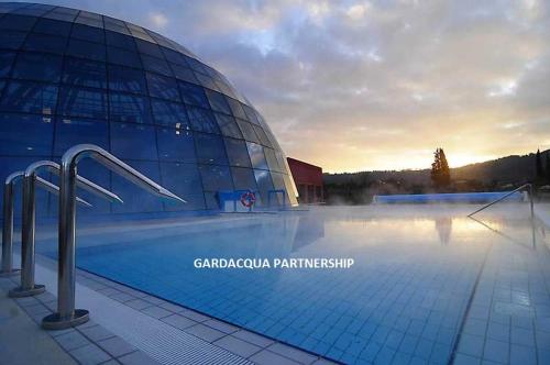 a swimming pool in front of a building at Hotel Dependance Silvestro in Garda