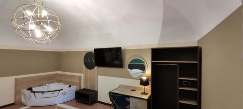 San Marciano Luxury Rooms في لاكويلا: غرفة بها مكتب وتلفزيون على السقف