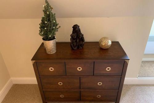 a dresser with a christmas tree on top of it at The Cartlodge in Wickham Bishops