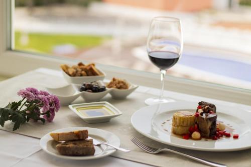a table with a plate of food and a glass of wine at Luna Hotel Turismo in Abrantes