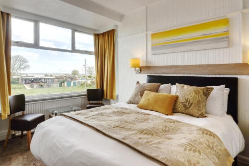 a bedroom with a large bed and a large window at Palm Court in Skegness