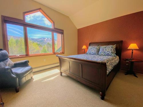 ein Schlafzimmer mit einem Bett, einem Stuhl und einem Fenster in der Unterkunft W8 Mount Washington Place Townhome great slope views fireplace large deck yard and ping pong in Carroll