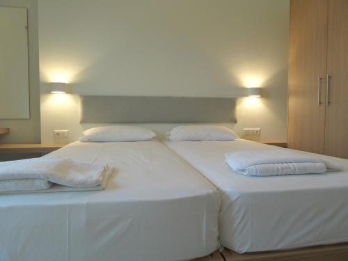 a large white bed with two pillows on it at Neapolis Apartments in Palaiochóra