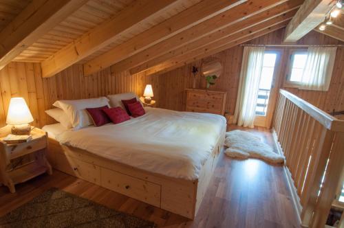 a bedroom with a large bed in a log cabin at Chalet Lisa Ski-in, ski-out Well equipped in Nendaz