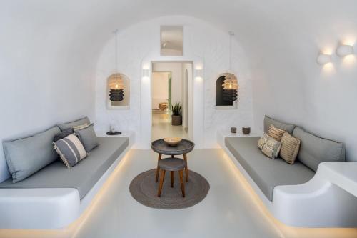 a living room with two couches and a table at Deep in cave suites in Fira