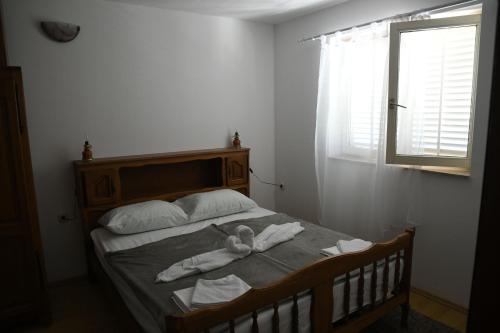 a bedroom with a bed with towels and a window at Apartman Endy in Ploče