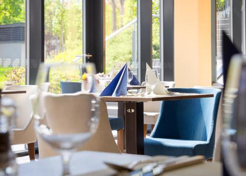 a restaurant with tables and chairs and a window at Hunguest Hotel Sóstó in Nyíregyháza