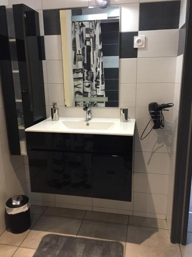 une salle de bain avec un lavabo et un miroir dans l'établissement Cosy au coeur des 3 vallées, à Argelès-Gazost