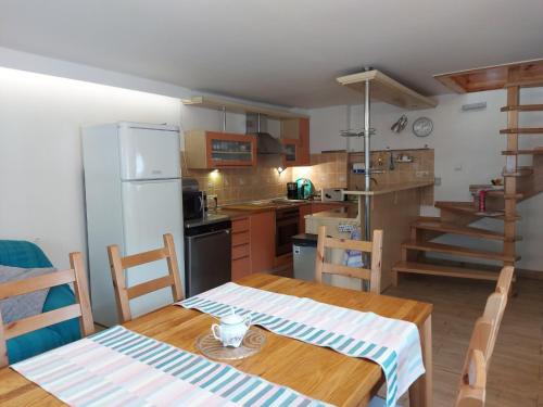 eine Küche mit einem Holztisch und einem Kühlschrank in der Unterkunft Apartament na Rybnej in Polanica-Zdrój