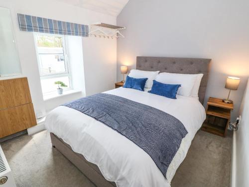 1 dormitorio con 1 cama grande con almohadas azules en Ferndale, en Pwllheli