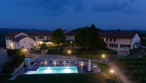 a house with a swimming pool at night at Locanda Del Pilone in Alba