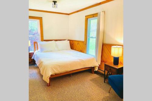 een slaapkamer met een bed en een raam bij Cozy and Charming Cottage with Jacuzzi and Fire Pit! in Livingston Manor